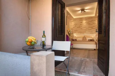 a table with a bowl of fruit and a bottle of wine at Luxury Boutique Studio Apartments in Budva