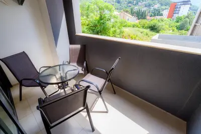 a balcony with two chairs and a table and a window at N Apartments in Sutomore