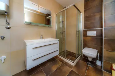a bathroom with a sink and a shower and a toilet at N Apartments in Sutomore