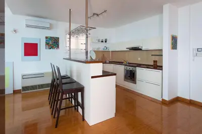 a kitchen with white cabinets and a table and chairs at Vidikovac Marble House in Budva
