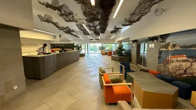 an office lobby with a man standing at a counter at Hotel Castellastva in Petrovac na Moru