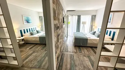 a hotel room with two beds and a mirror at Hotel Castellastva in Petrovac na Moru