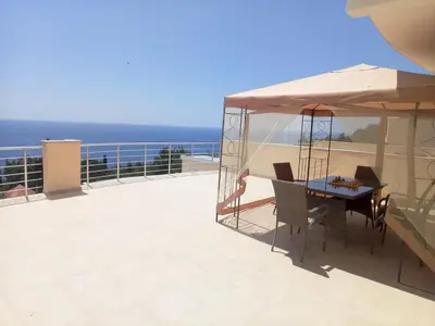 a table and chairs on a balcony with the ocean at Villa Roan in Bar