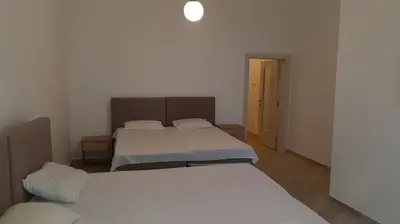 a bedroom with two beds and a door to a room at Villa Roan in Bar