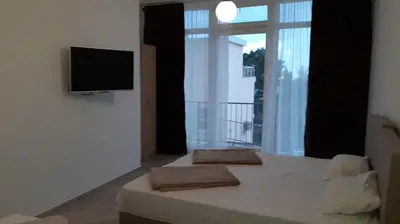 a bedroom with a bed and a tv and a window at Villa Roan in Bar