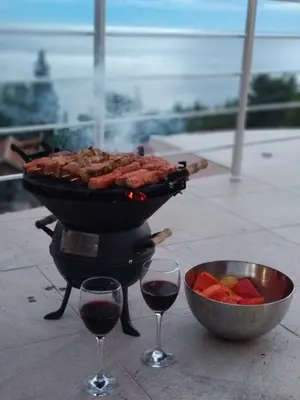 a grill with meat and two glasses of wine at Villa Roan in Bar