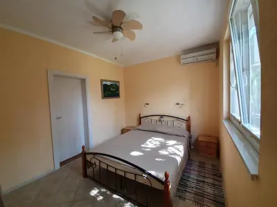 a bedroom with a bed and a ceiling fan at Villa Rolla in Tivat