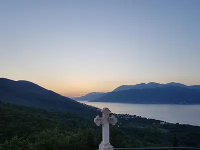 a cross on top of a hill with the sunset at Villa Rolla in Tivat