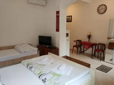 a bedroom with two beds and a table and chairs at Apartment Monika in Kotor