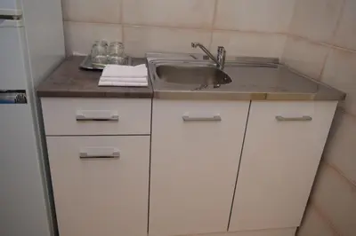 a kitchen with white cabinets and a sink at Apartment Monika in Kotor