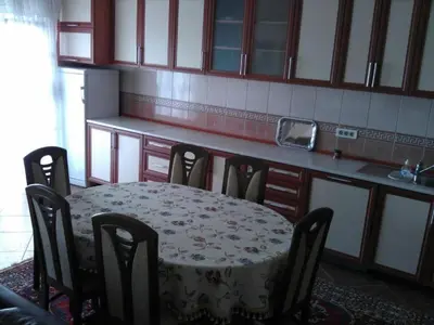 a table and chairs in a kitchen with a table and a counter at Apartmani Djurovic in Dobra Voda
