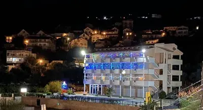 a building with blue lights on it at night at Apartmani Djurovic in Dobra Voda