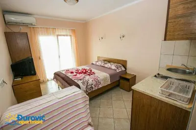 a bedroom with a bed and a sink in a room at Apartmani Djurovic in Dobra Voda