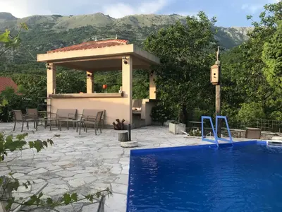 a swimming pool with a gazebo and a house at Guest house Duletic in Budva