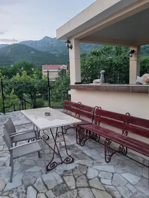 a wooden bench and a table on a patio at Guest house Duletic in Budva