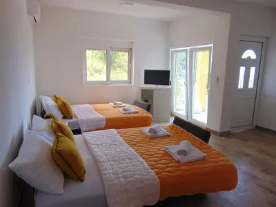 a room with two beds and a television at Apartments Bibic in Budva