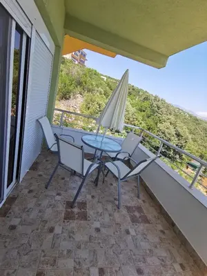 a patio with a table and chairs and an umbrella at Apartments Bibic in Budva