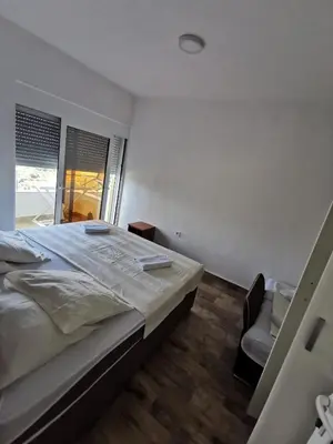 a bedroom with a large bed and a chair at Apartments Bibic in Budva