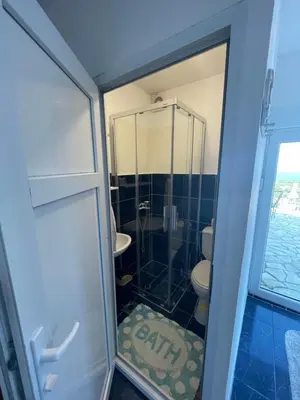 a bathroom with a glass shower and a toilet at Apartments Bibic in Budva