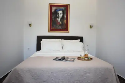 a bedroom with a bed with a picture on the wall at Apartmani Ognjanovic Kotor in Kotor