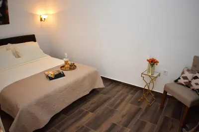 a small bedroom with a bed and a chair at Apartmani Ognjanovic Kotor in Kotor