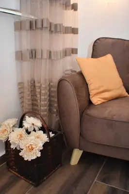 a living room with a couch and a basket of flowers at Apartmani Ognjanovic Kotor in Kotor