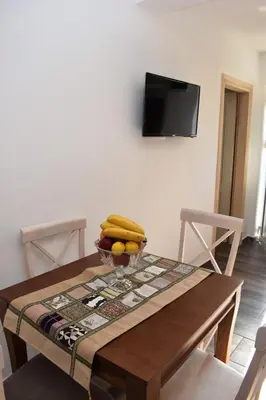 a dining room table with a bowl of fruit on it at Apartmani Ognjanovic Kotor in Kotor