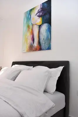 a bedroom with a bed with a painting on the wall at Apartmani Ognjanovic Kotor in Kotor