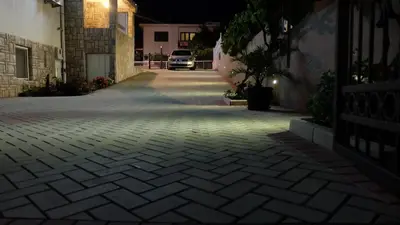 a car driving down a driveway at night at Apartments Kojic in Bar