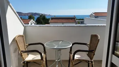 a table and two chairs on a balcony with a view at Apartments Kojic in Bar