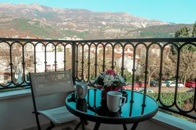 a table and a chair on a balcony with a view at Hotel Villa Gracia in Budva