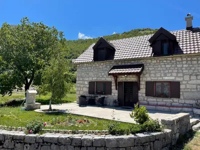 a stone house with a stone wall at Lovcen Holiday Home in Cetinje