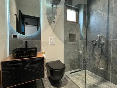 a bathroom with a shower and a toilet and a mirror at Blue Star Apartments in Ulcinj