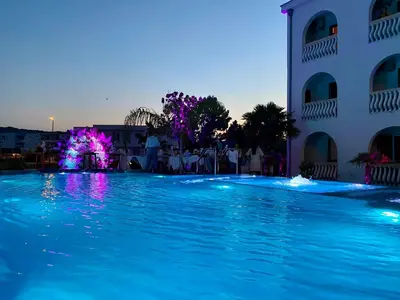 a swimming pool with a fountain in front of a building at Blue Star Apartments in Ulcinj