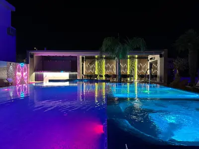 a swimming pool at night with purple and blue lights at Blue Star Apartments in Ulcinj