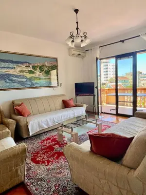 a living room with two couches and a glass table at Adriatic Apartments in Ulcinj