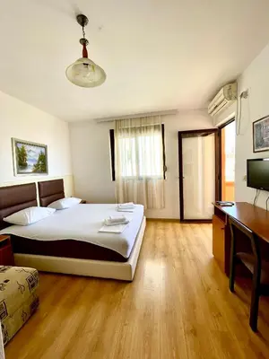 a bedroom with a large bed and a desk at Adriatic Apartments in Ulcinj