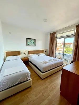 two beds in a hotel room with a window at Adriatic Apartments in Ulcinj