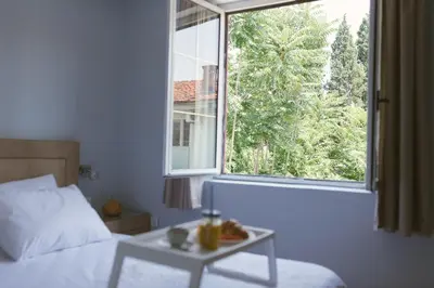a bedroom with a bed and a table and a window at Apartment Luxury Explorer in Podgorica