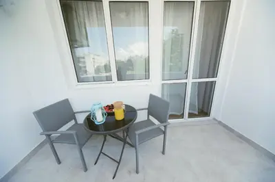 a table and chairs in a room with a window at Apartment Luxury Explorer in Podgorica