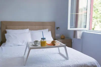 a table with a tray of food on a bed at Apartment Luxury Explorer in Podgorica