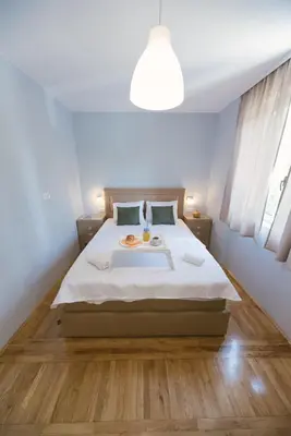 a bedroom with a large bed and a light at Apartment Luxury Explorer in Podgorica
