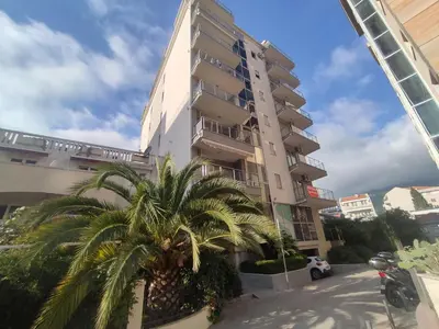 a tall building with a palm tree in front of it at Adrialux2 in Budva