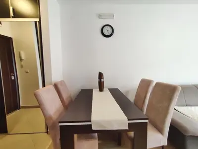 a dining room table with chairs and a clock on the wall at Adrialux2 in Budva