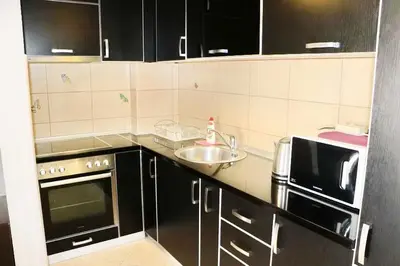 a small kitchen with black cabinets and a sink at Adrialux2 in Budva