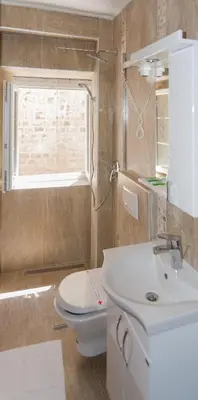 a bathroom with a sink and a toilet and a window at Hotel Rendez Vous in Kotor