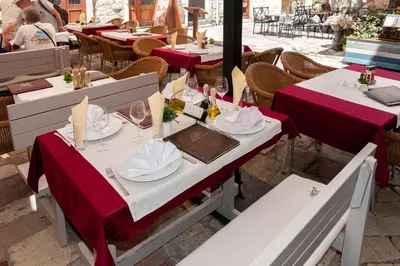 a table with red table cloths on tables in a restaurant at Hotel Rendez Vous in Kotor