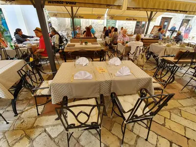 a restaurant with tables and chairs and people sitting at tables at Hotel Rendez Vous in Kotor