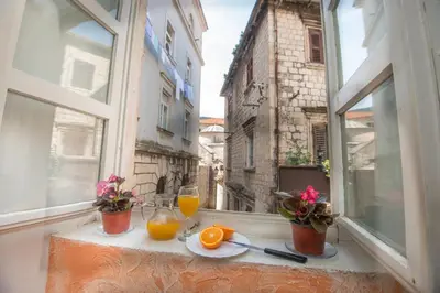 an open window with a table with oranges and juice at Hotel Rendez Vous in Kotor
