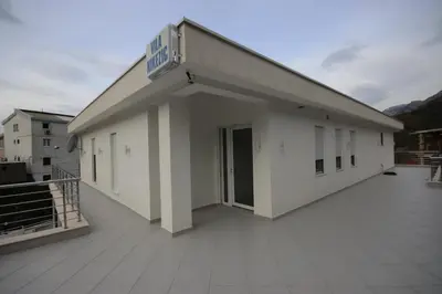 a large white building with a large balcony at Vila Nikezić in Sutomore
